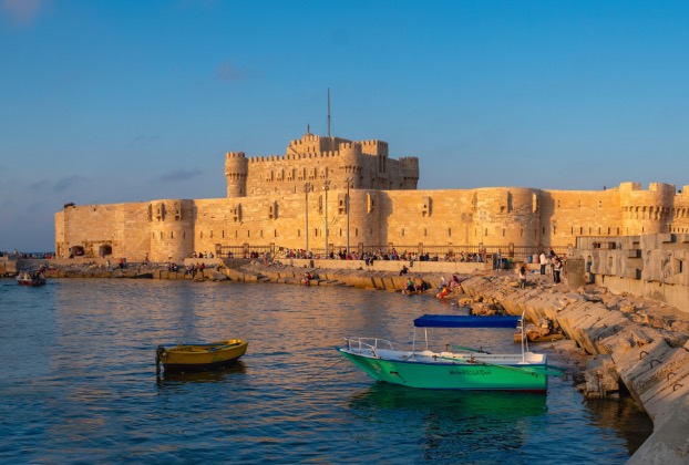 Historic castle beside a tranquil waterfront.