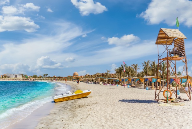 Sunny beach with a lifeguard tower and boat
